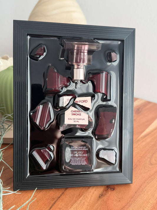 Gerahmtes Kunstwerk mit Tom Ford Cherry Smoke Parfumflakon in schwarzem Rahmen, eingebettet in glänzendem Resin, moderne Luxus Wanddekoration, Parfum Kunst, 3D Resin Art, Interior Design Dekoration“